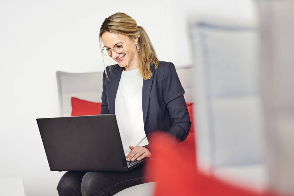 Celine Spitz está trabajando con su ordenador portátil en el sofá de la sala de estar de kwsoft.