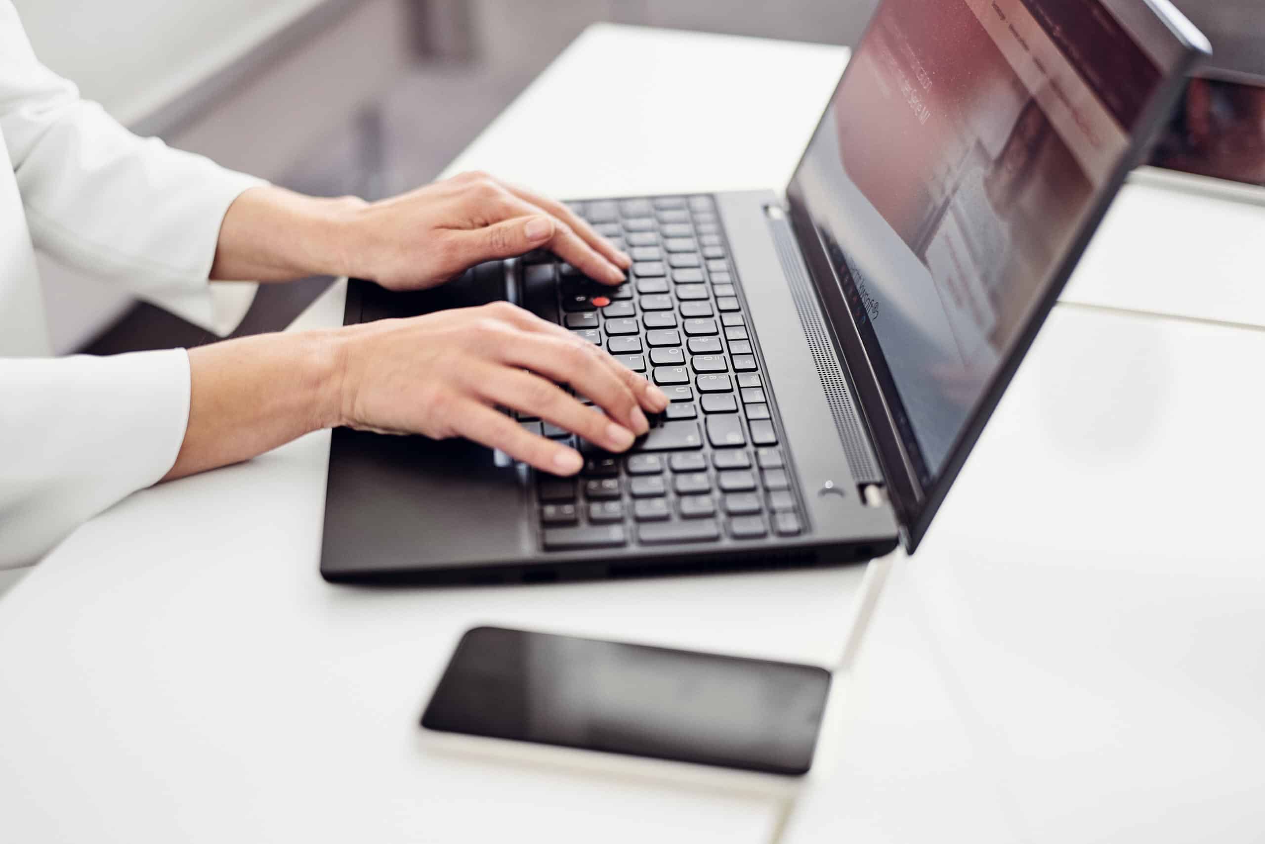 Una persona está sentada frente a un ordenador portátil y está visitando la página web de kwsoft®.