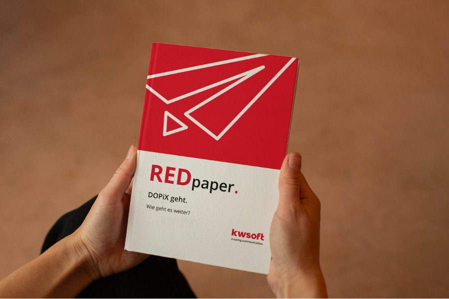 La imagen muestra a una persona sosteniendo el REDpaper sobre la sustitución de «DOPiX».